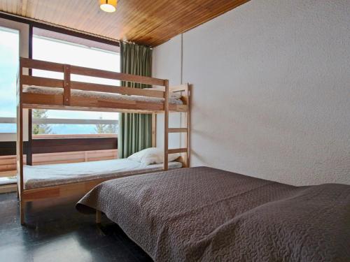 a bedroom with two bunk beds and a window at Appartement Chamrousse, 3 pièces, 8 personnes - FR-1-549-108 in Chamrousse