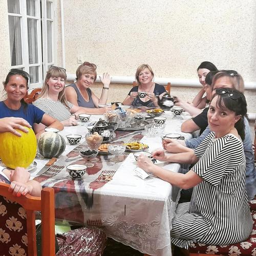 a group of women sitting around a table at Shodlik Guest House in Khiva