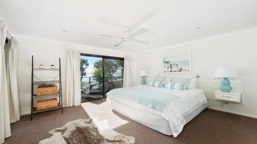 a white bedroom with a bed and a window at Dutchie's Dream - Glorious Views And Opposite Dutchies Beach in Nelson Bay