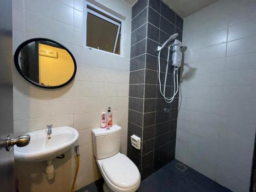 a bathroom with a toilet and a sink and a mirror at Camellia Mesahill Homestay in Nilai