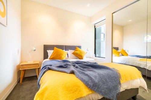 1 dormitorio con 2 camas y espejo en Luxury beachside apartment en Melbourne