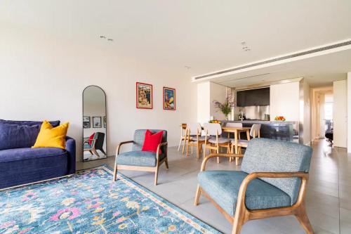 a living room with a couch and chairs and a table at Luxury beachside apartment in Melbourne