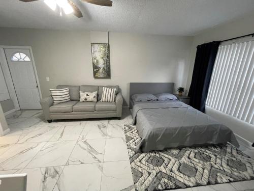 a bedroom with a bed and a couch at Adorable Suite in Tampa. in Tampa