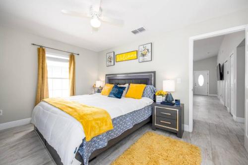 1 dormitorio con 1 cama grande con almohadas amarillas y azules en Modern Luxury Home Located in Tampa! en Tampa