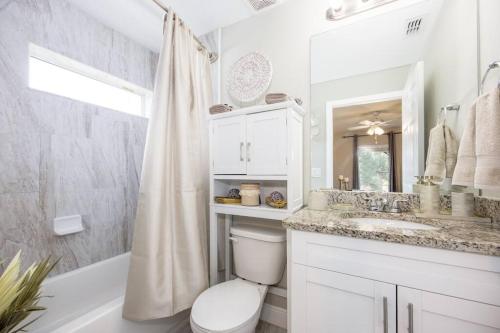 a bathroom with a toilet and a sink and a shower at Modern Luxury Home Located in Tampa! in Tampa