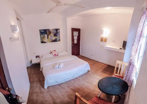 a bedroom with two beds and a table and a chair at Sea Horse Guest House in Coron