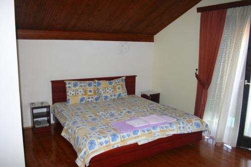a bedroom with a bed with a wooden headboard at Villa Filip in Trpejca