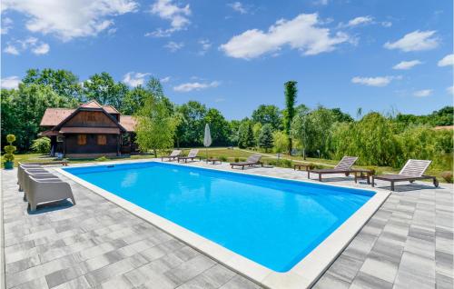 a swimming pool with chairs and a house at Beautiful Home In Mala Ludina With Wifi in Mala Ludina