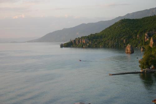 a person in a boat on a lake with mountains at Villa Filip in Trpejca