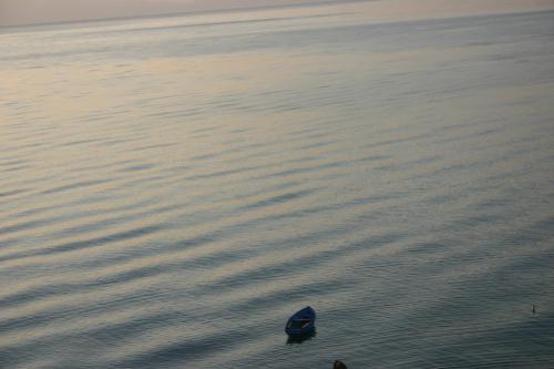 a small boat in the water at sunset at Villa Filip in Trpejca