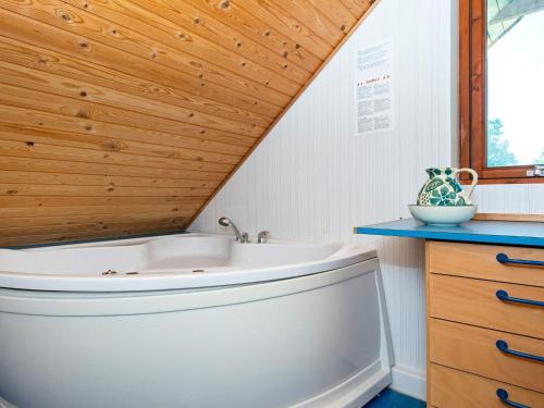 ein Badezimmer mit einer Badewanne und einer Holzdecke in der Unterkunft Holiday home Ørsted XII in Ørsted
