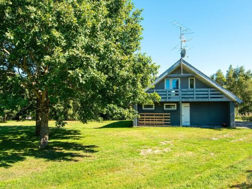 a house with a tree in front of it at 11 person holiday home in Ørsted-By Traum in Ørsted