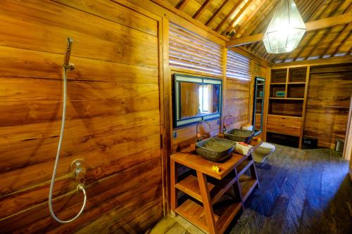 a wooden bathroom with two sinks and a shower at Canggu Wooden Green Paradise in Canggu
