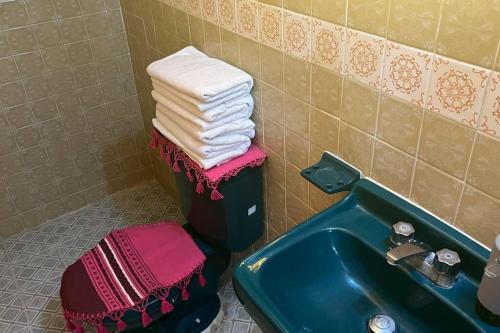 a bathroom with a sink and a pile of towels at Amplio Dpto. céntrico con cochera y terraza. in San Cristóbal de Las Casas