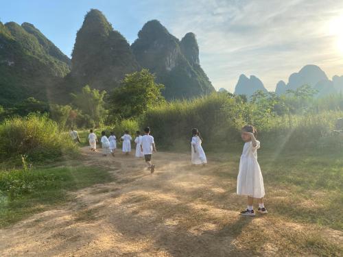 a group of people walking down a dirt road at The Apsara Lodge-Airport or TS Free pick-up over 3 nights in Yangshuo