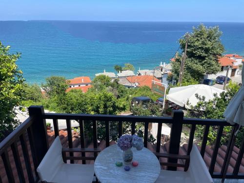 a table on a balcony with a view of the ocean at Villa Sunray in Agios Ioannis Pelio