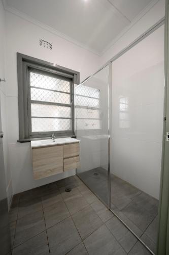 ein Badezimmer mit Waschbecken und Fenster in der Unterkunft The Coramba Hotel in Coramba
