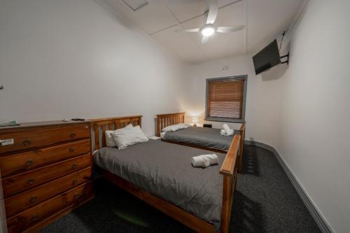ein Schlafzimmer mit einem Bett und einer Kommode in der Unterkunft The Coramba Hotel in Coramba