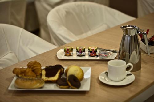 un tavolo con un piatto di prodotti da forno e una tazza di caffè di Chic Hotel ad Atene