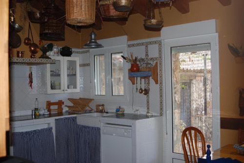 a kitchen with white cabinets and a counter top at Casa Rural Rincon de la Vega in Los Cortos