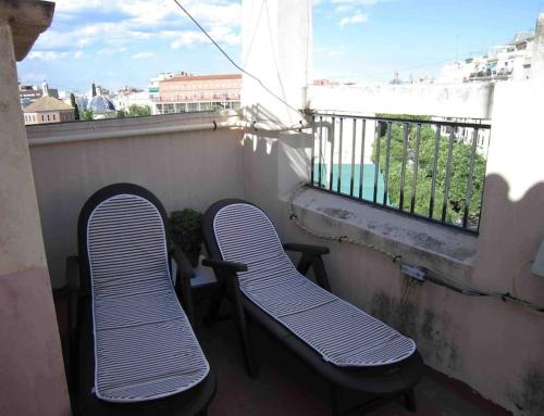 two chairs sitting on a balcony with a view at Young Penthouse in Valencia