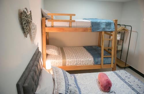 a room with two bunk beds and a couch at Casa Tangara Café y Hospedaje in Medellín