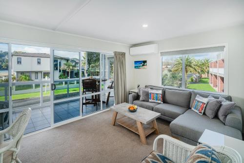 a living room with a couch and a table at Waterfront Apartments Whitianga in Whitianga