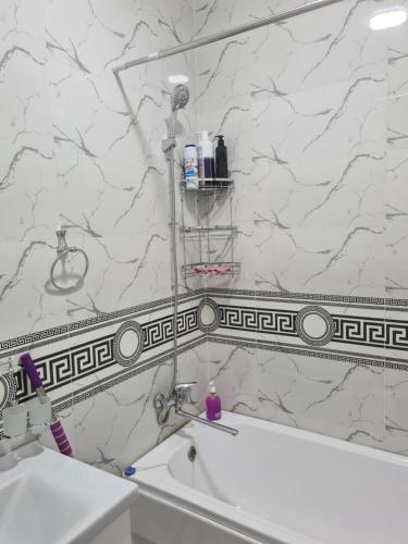 a bathroom with a white and black marble wall at 2-х комнатная квартира in Tashkent