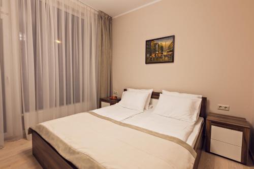 a bedroom with a large bed with white sheets at Sonia Apartments in Jūrmala
