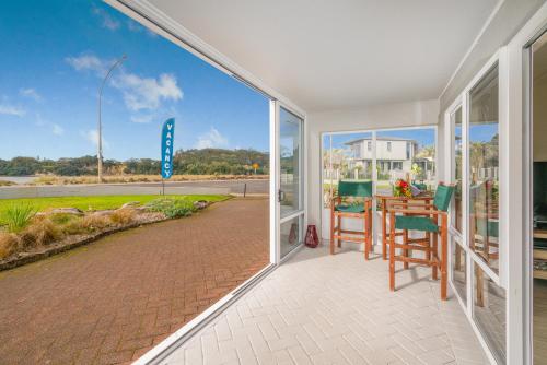 an open living room with a table and chairs at Waterfront Apartments Whitianga in Whitianga