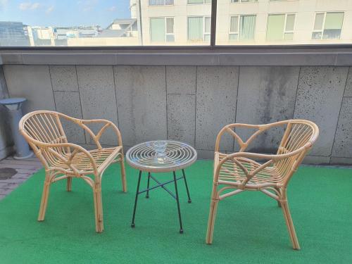 two chairs and a table on a balcony at JS Boutique Hotel in Hwaseong