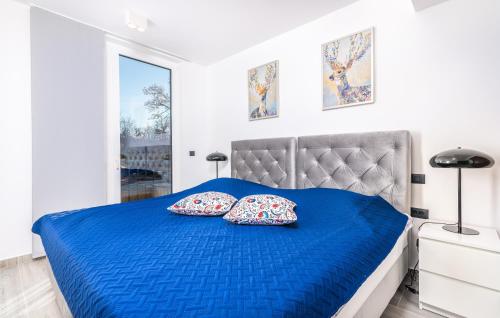 ein Schlafzimmer mit einem blauen Bett mit zwei Kissen in der Unterkunft Family friendly house with a swimming pool Vantacici, Krk - 19263 in Malinska