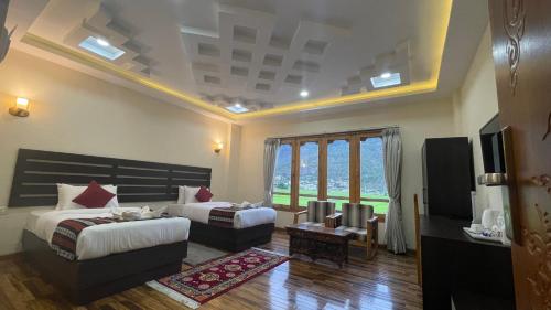 a hotel room with two beds and a television at Zhideychen Resort in Paro