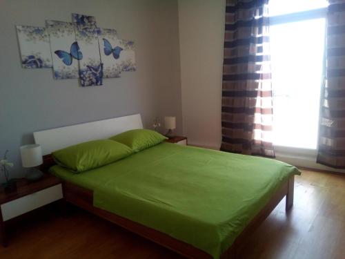 a bedroom with a bed with green sheets and a window at Apartments by the sea Brist, Makarska - 19330 in Podaca