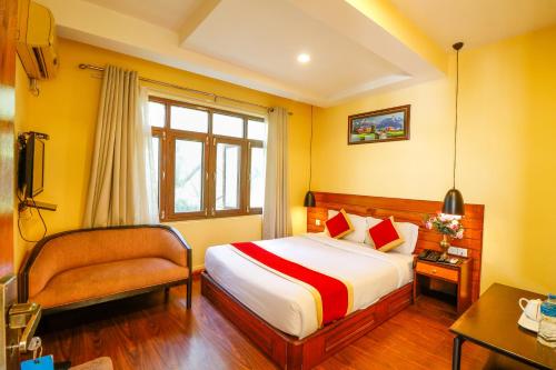 a hotel room with a bed and a chair at Hotel Blue Horizon in Kathmandu