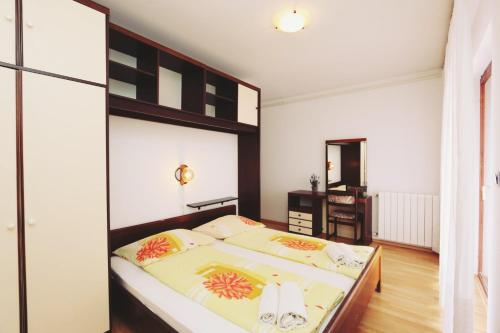 a bedroom with a large bed and a desk at Apartments by the sea Malinska, Krk - 19264 in Malinska