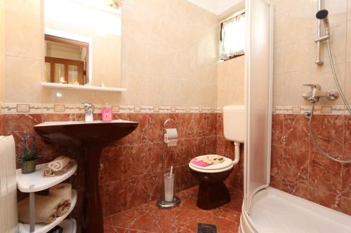 a bathroom with a sink and a toilet and a shower at Apartments by the sea Malinska, Krk - 19264 in Malinska