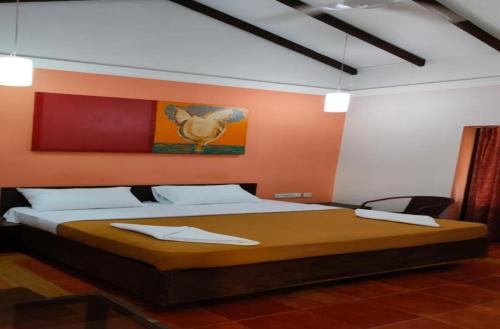 a bedroom with a large bed with orange walls at Miramar Residency in Panaji
