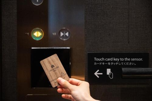 a person holding a piece of paper in front of an toaster at Nikko Style Nagoya in Nagoya