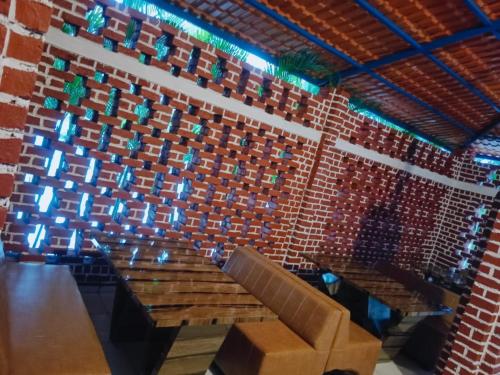 a room with a brick wall with a table and chairs at RAJ RESORT & BANQUETS in Vapi