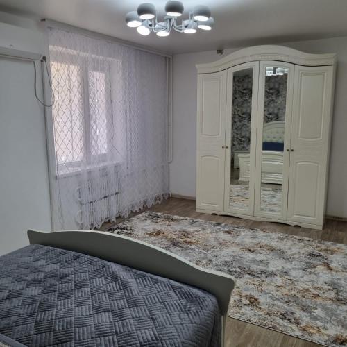 um quarto com uma cama, um armário e uma janela em Квартира у моря em Aktau