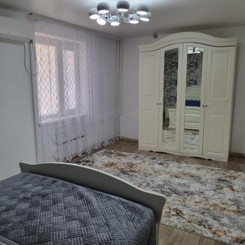 ein Schlafzimmer mit einem Bett, einem Schrank und einem Fenster in der Unterkunft Квартира у моря in Aqtau