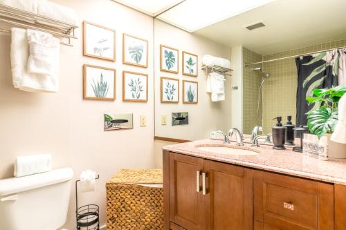 a bathroom with a sink and a toilet and a mirror at Waiakea Villas 2-207 in Hilo