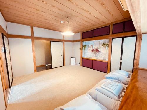 a large room with two beds and a window at SAMURISE DARUMA in Fujiyoshida