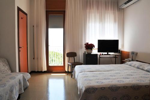 a hotel room with two beds and a television at Hotel Reno in Lido di Jesolo
