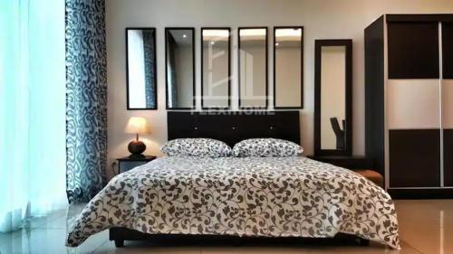 a bedroom with a bed with a black and white comforter at 1-2 Guests, HBO-GO TV, Bali-Style Studio in Cybersquare, Cyberjaya by Flexihome-MY in Cyberjaya