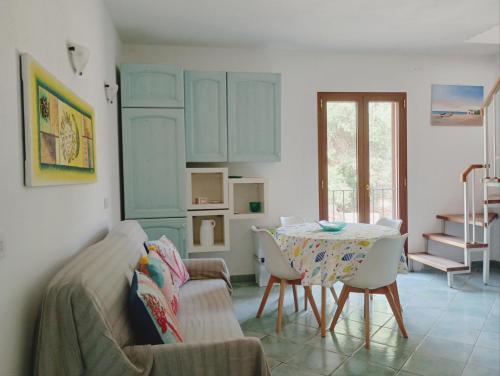un soggiorno con tavolo e sedie di Appartamento La Terrazza - Località Cala Gavetta a La Maddalena