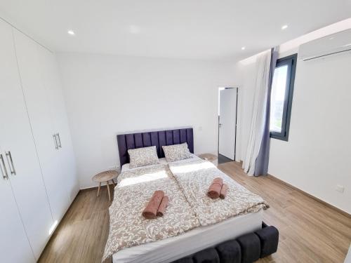 a bedroom with a large bed with slippers on it at Lucky Strike Apartment in Nicosia