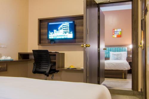 a hotel room with a bed and a television at Hotel Horizon Entebbe in Entebbe
