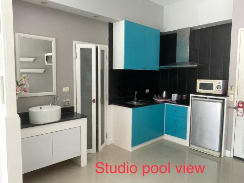 a kitchen with blue and white cabinets and a sink at Thalassa Kata Beach in Kata Beach